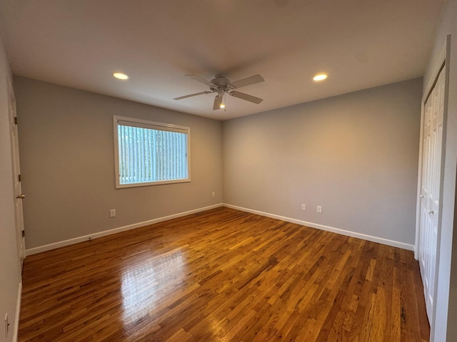 unfurnished bedroom with ceiling fan, dark hardwood / wood-style flooring, and a closet