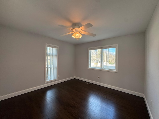 empty room featuring dark wood-type flooring and ceiling fan