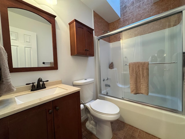 full bathroom with bath / shower combo with glass door, vanity, and toilet