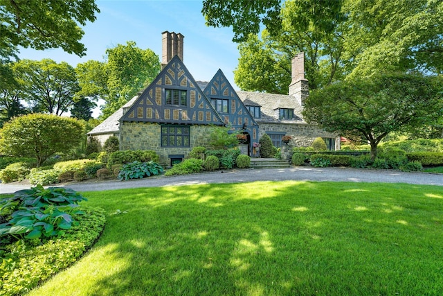 tudor home with a front lawn