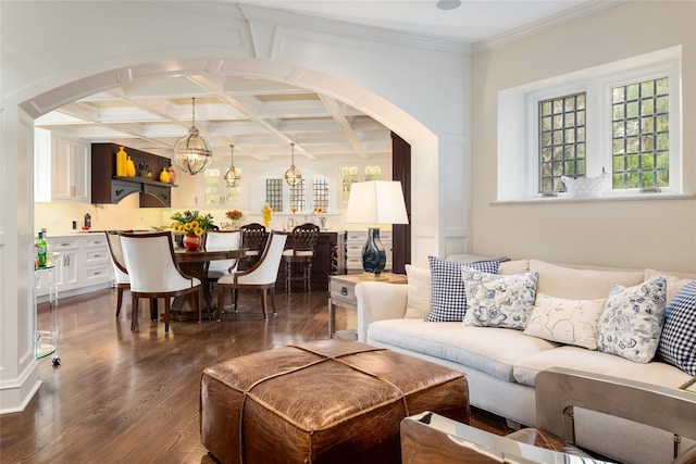 living room with beam ceiling, dark hardwood / wood-style floors, coffered ceiling, ornamental molding, and a chandelier