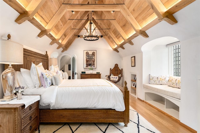 bedroom featuring a notable chandelier, wood ceiling, light wood-type flooring, and beamed ceiling