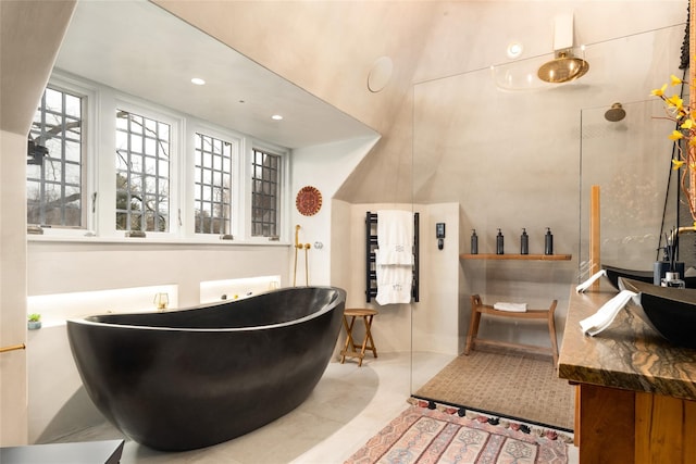 bathroom featuring vanity, a bath, and tile patterned floors