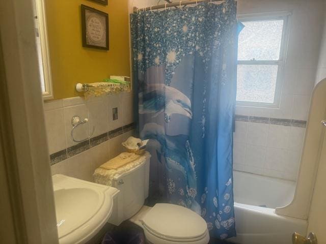 full bathroom featuring toilet, sink, tile walls, and shower / bath combo