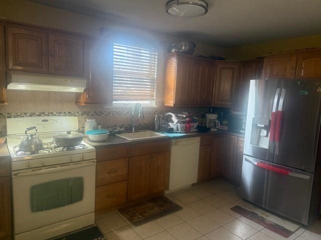 kitchen featuring light tile patterned flooring, sink, backsplash, and white appliances