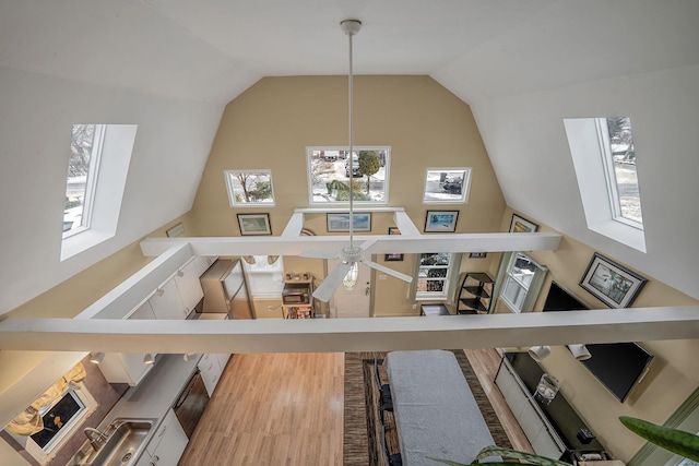 living room featuring ceiling fan, lofted ceiling, and wood-type flooring