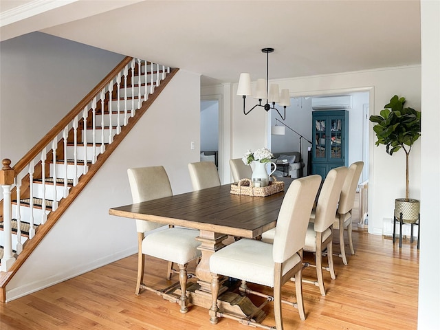 dining room with a chandelier, light wood-type flooring, and an AC wall unit