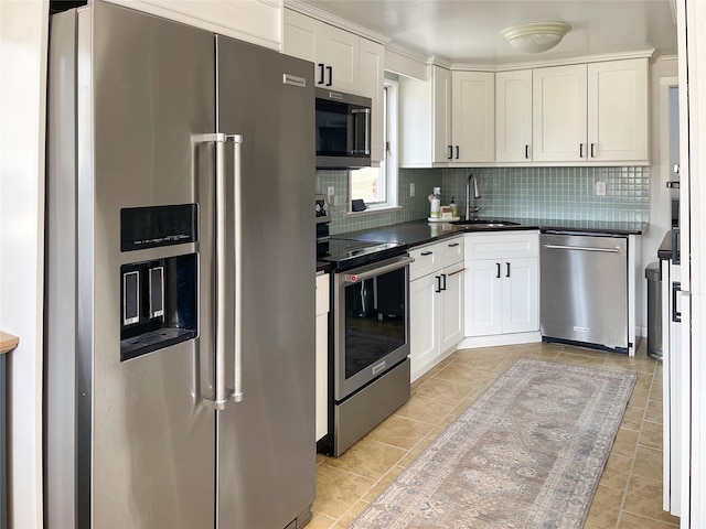 kitchen with sink, light tile patterned floors, white cabinets, stainless steel appliances, and backsplash