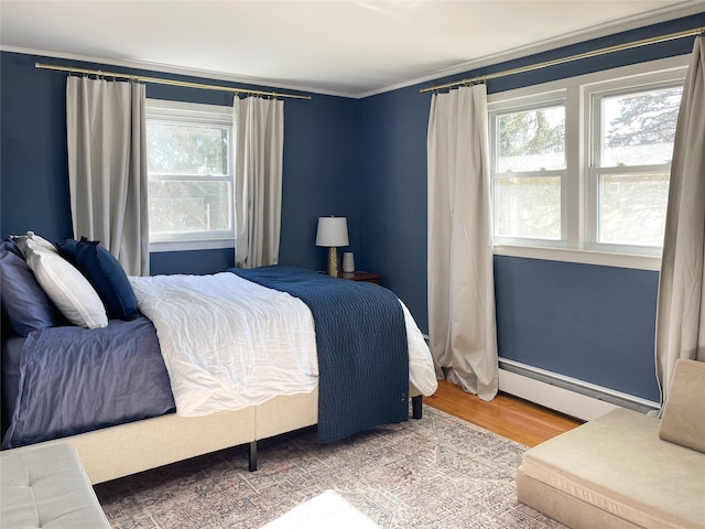 bedroom featuring baseboard heating and hardwood / wood-style floors