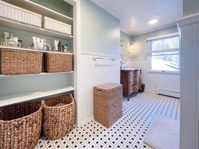 bathroom featuring baseboard heating, ornamental molding, and vanity