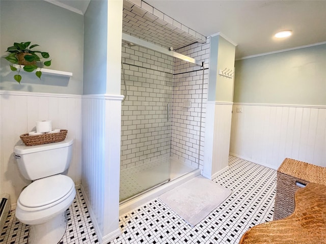 bathroom with tile patterned flooring, ornamental molding, a shower with door, and toilet