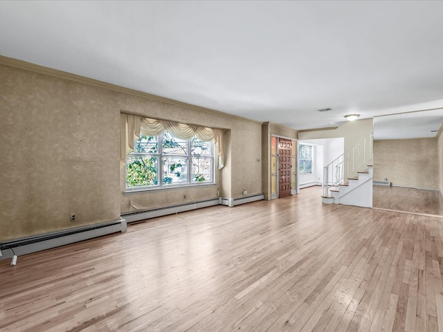 unfurnished living room featuring crown molding, light hardwood / wood-style floors, and baseboard heating