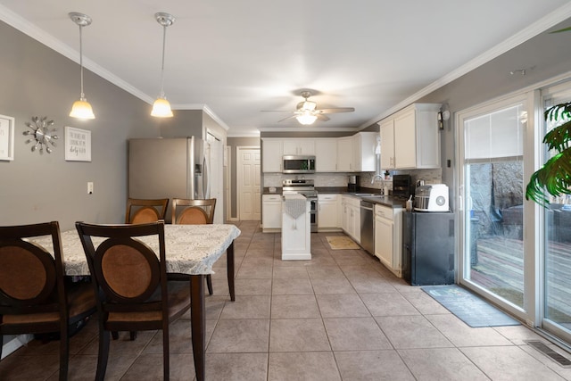 kitchen with light tile patterned flooring, appliances with stainless steel finishes, pendant lighting, sink, and white cabinets