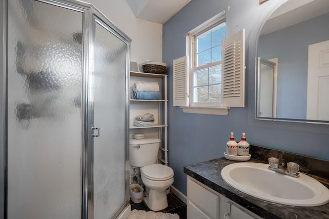 bathroom with tile patterned flooring, vanity, an enclosed shower, and toilet