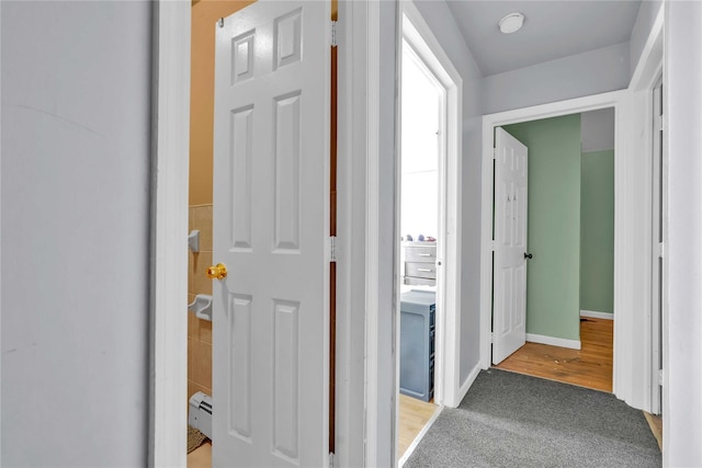 hallway featuring a baseboard radiator and light colored carpet