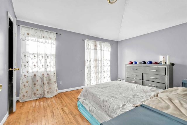 bedroom with hardwood / wood-style flooring and vaulted ceiling