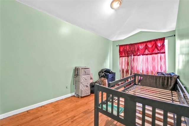 bedroom with lofted ceiling and hardwood / wood-style flooring