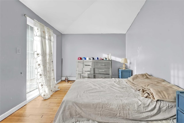 bedroom featuring wood-type flooring and vaulted ceiling