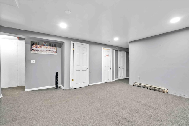 basement with a baseboard heating unit and carpet flooring