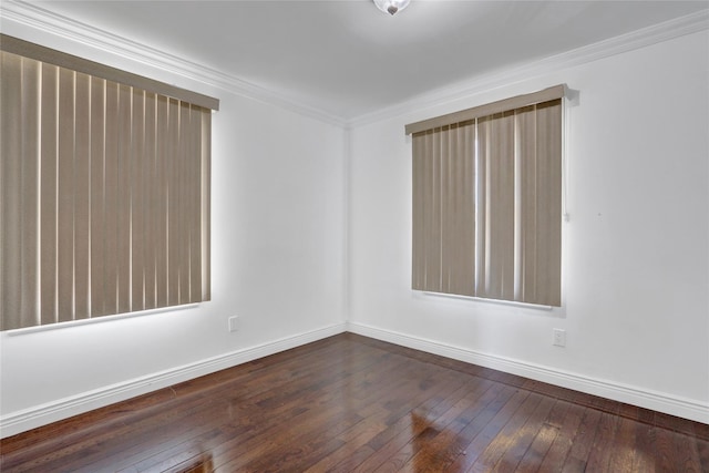 empty room with ornamental molding and dark hardwood / wood-style floors