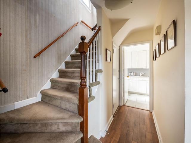 stairs featuring hardwood / wood-style flooring and sink