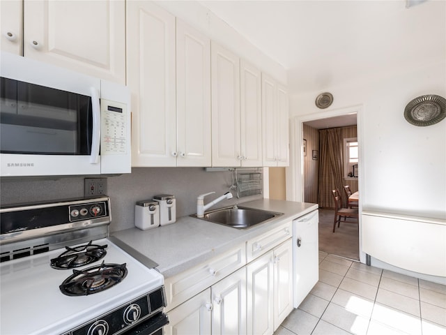 kitchen with white cabinetry, white appliances, sink, and light tile patterned floors