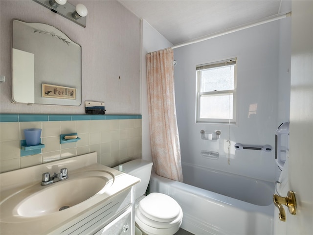 full bathroom with vanity, tile walls, toilet, and shower / tub combo with curtain