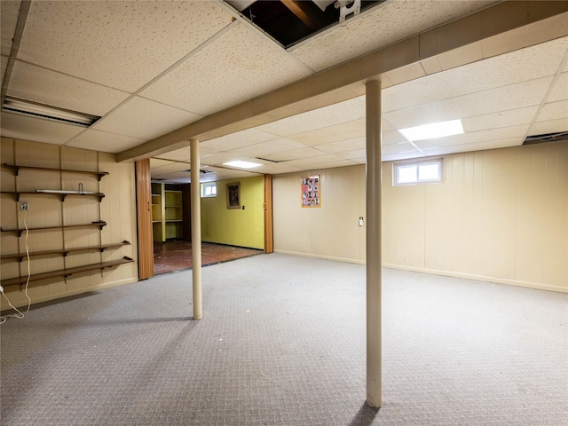 basement with carpet and a paneled ceiling