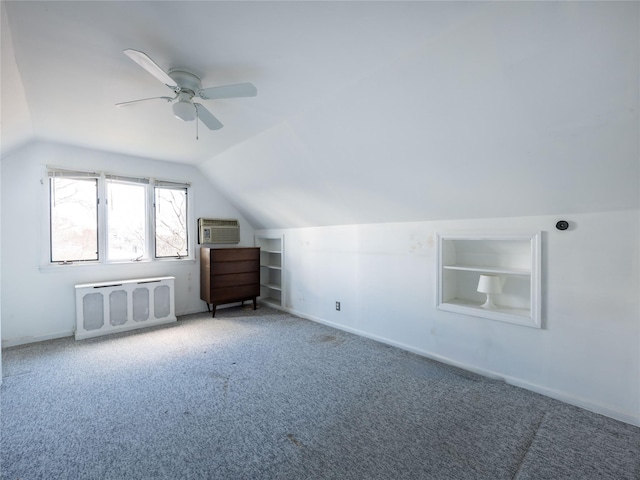 bonus room featuring lofted ceiling, radiator, built in features, a wall mounted AC, and carpet flooring