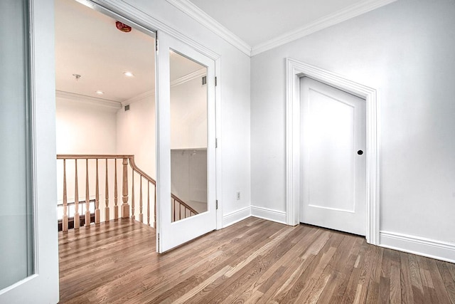 hall featuring baseboards, crown molding, an upstairs landing, and wood finished floors