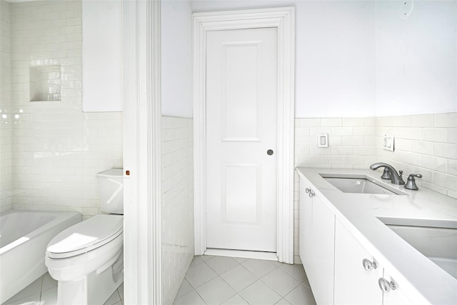 full bathroom featuring double vanity, a washtub, tile walls, and a sink