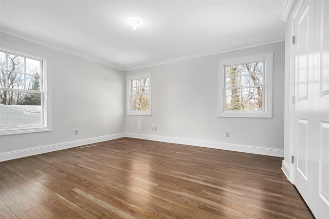 empty room with ornamental molding, dark wood finished floors, and baseboards