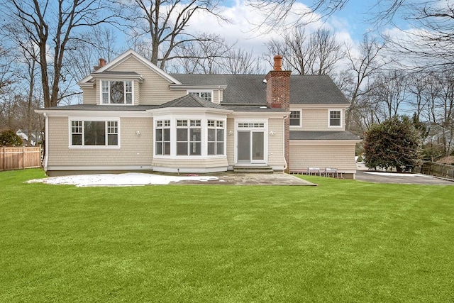 back of house with a patio, a chimney, a lawn, a sunroom, and fence