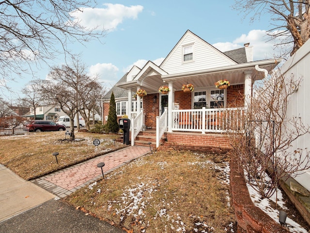 view of front of house with a front yard and a porch