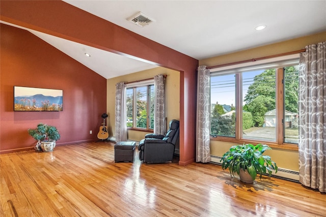 sitting room with a baseboard radiator, lofted ceiling, and light hardwood / wood-style flooring