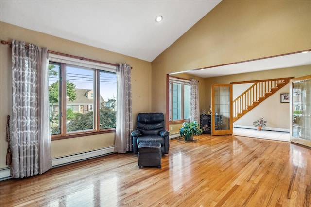 living area featuring hardwood / wood-style flooring, high vaulted ceiling, and baseboard heating