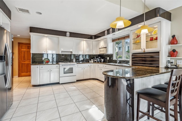 kitchen with white cabinetry, hanging light fixtures, white appliances, and kitchen peninsula