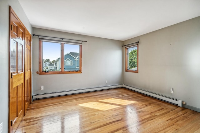 spare room featuring a baseboard radiator and light wood-type flooring