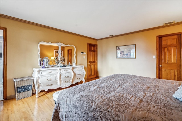 bedroom with crown molding and light hardwood / wood-style floors