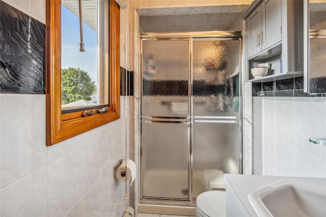 bathroom featuring walk in shower, vanity, toilet, and tile walls