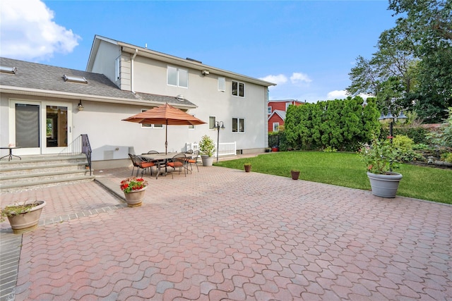 back of house with a yard and a patio