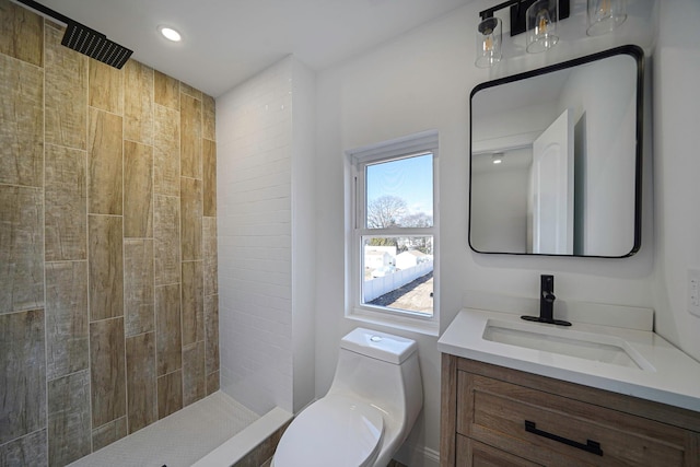 bathroom with vanity, toilet, and a tile shower