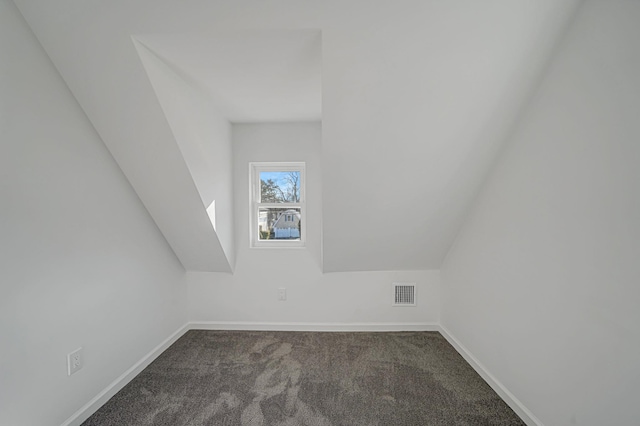 additional living space with dark colored carpet