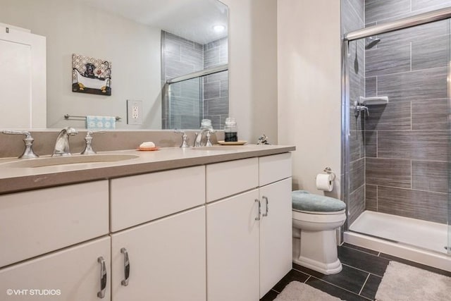 bathroom with an enclosed shower, vanity, tile patterned flooring, and toilet