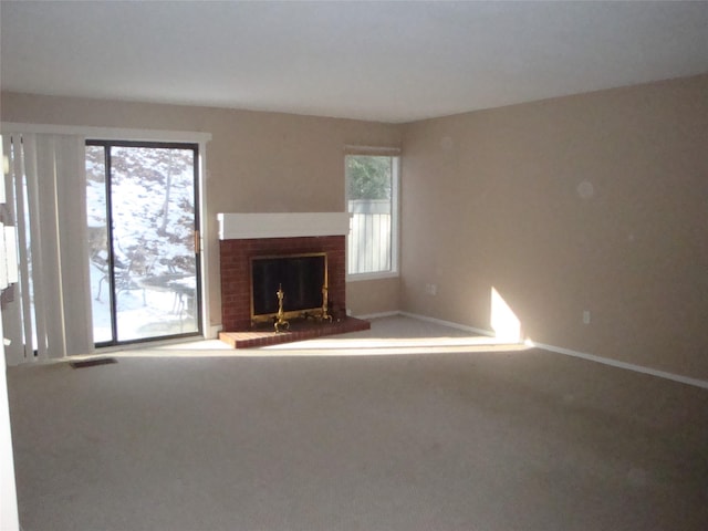 unfurnished living room with carpet flooring and a fireplace