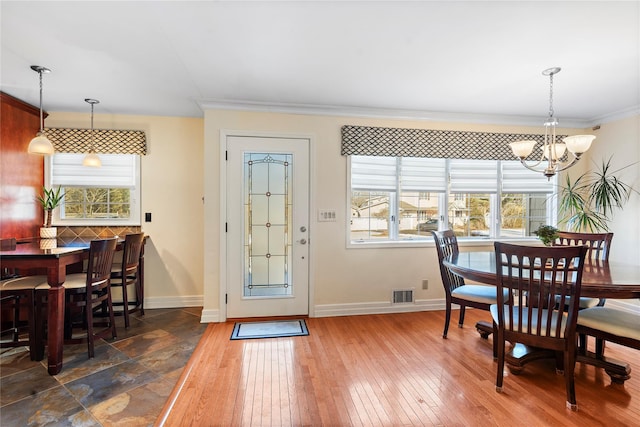 dining room featuring crown molding, dark hardwood / wood-style floors, and a chandelier