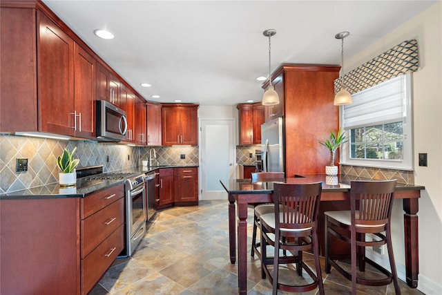 kitchen featuring pendant lighting, stainless steel appliances, sink, and tasteful backsplash