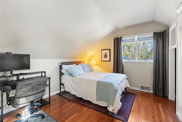 bedroom with dark wood-type flooring and vaulted ceiling