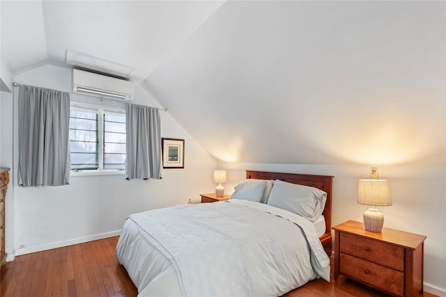 bedroom with wood-type flooring, vaulted ceiling, and a wall mounted air conditioner