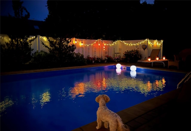 view of pool at twilight